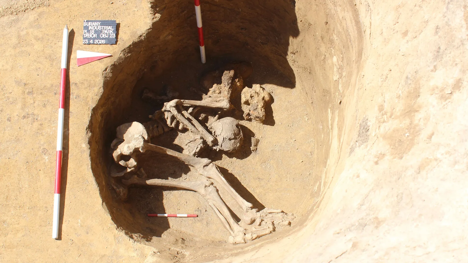 a human skeleton in a curled position at the bottom of a well